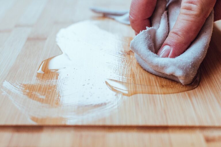 Auftragen von Holzpflegeöl auf ein Schneidebrett für Lebensmittel.